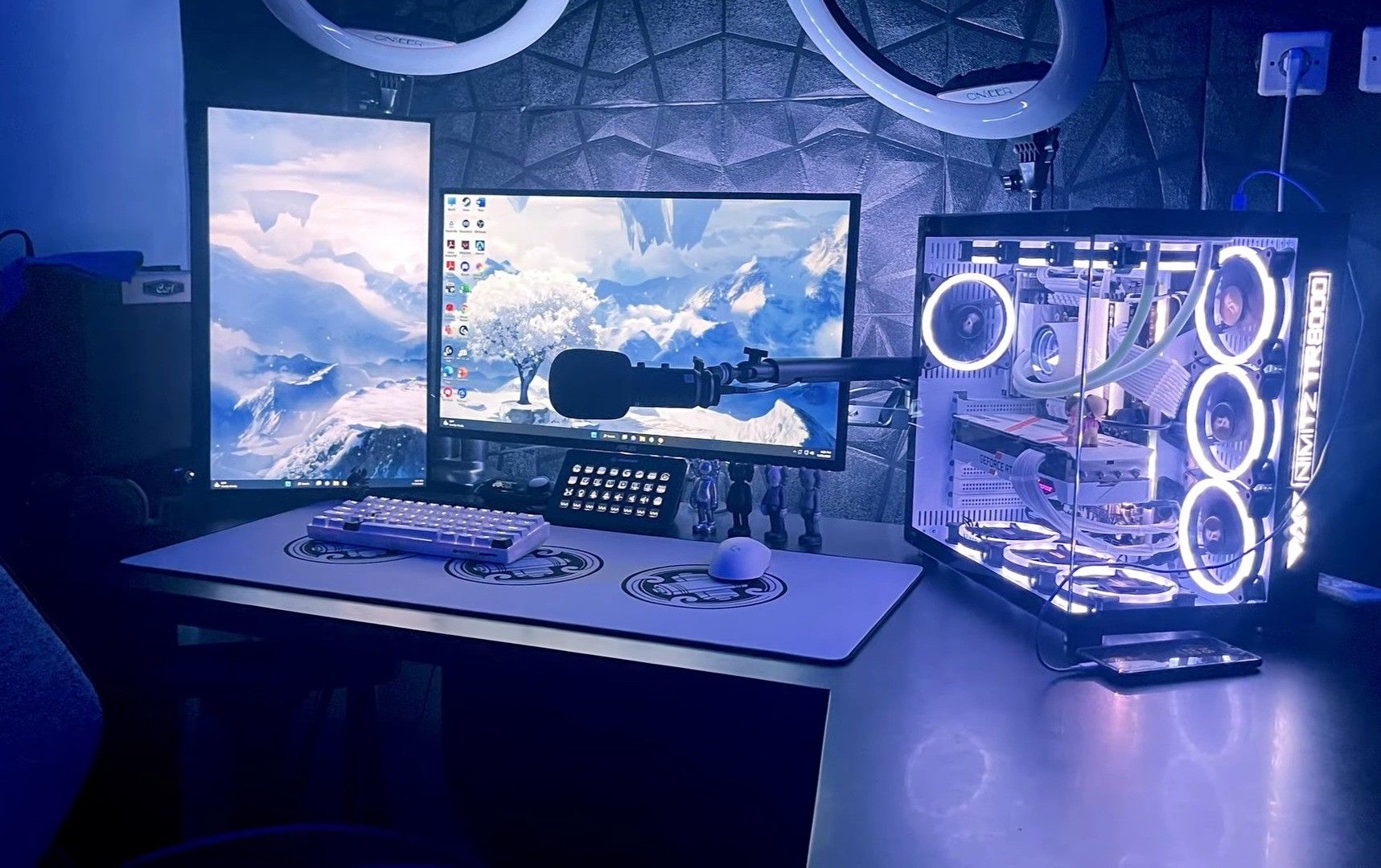 High-end gaming desk set up with multiple screens and custom lighting